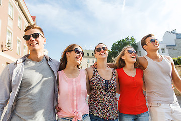 Image showing group of smiling friends walking in city