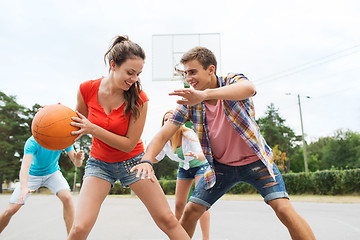 Image showing group of happy teenagers playing basketball