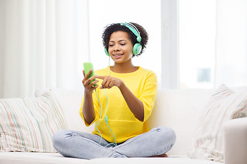 Image showing happy african woman with smartphone and headphones