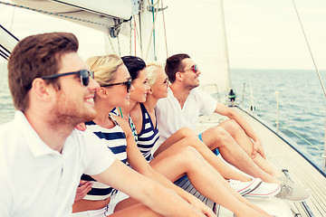 Image showing smiling friends sitting on yacht deck