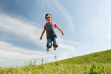 Image showing happy little girl jumping high outdoors