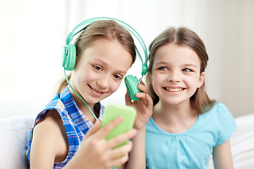Image showing happy girls with smartphone and headphones