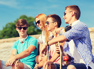 Image showing group of smiling friends sitting on city street