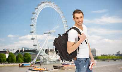 Image showing happy young man with backpack and book travelling