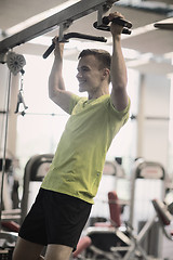 Image showing smiling man exercising in gym