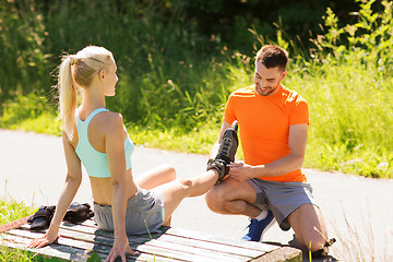 Image showing happy couple with roller skates outdoors