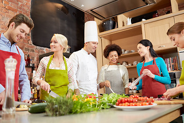 Image showing happy friends and chef cook cooking in kitchen