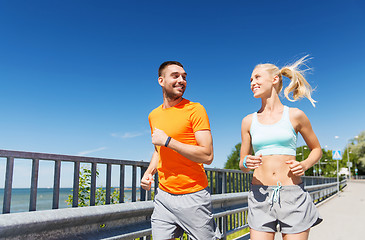 Image showing smiling couple running at summer seaside