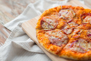 Image showing close up of homemade pizza on wooden table