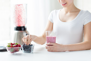 Image showing close up of woman with blender and milk shake