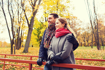 Image showing smiling couple hugging on bridge in autumn park