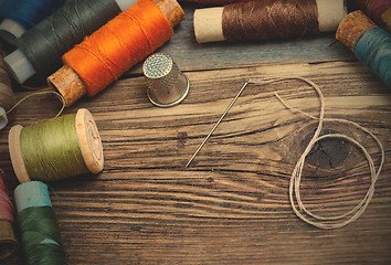 Image showing spool of thread, a thimble and a sewing needle