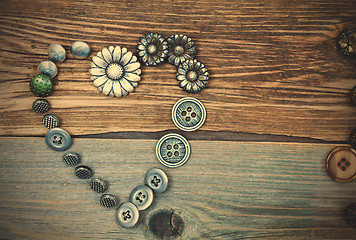 Image showing antique buttons heart on old textured boards