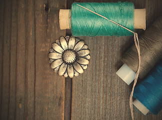 Image showing vintage button flower, spool of thread and a sewing needle