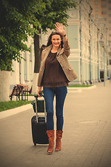 Image showing adult beautiful businesswoman with a suitcase walking along the 