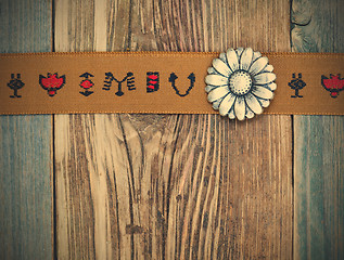 Image showing vintage band with embroidered ornaments and old button flower