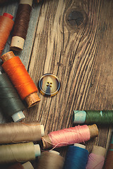 Image showing Vintage spools with multi colored threads and old button