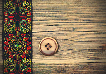 Image showing old band with embroidered ornaments and vintage button