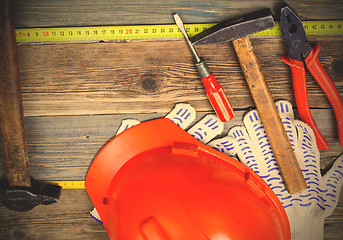 Image showing Vintage hammer, pliers, screwdriver, tape measure, a bright helm