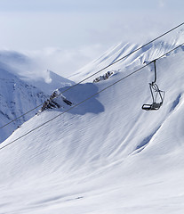 Image showing Chair lift at ski resort and off piste slope