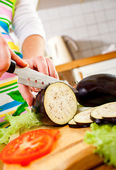 Image showing Woman\'s hands cutting aubergine eggplant