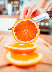 Image showing Woman\'s hands cutting orange