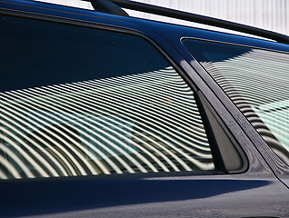 Image showing Car and stripes, car parked in front of a building with striped 