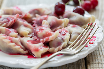 Image showing Dumplings with cherries and sour sauce.