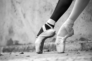 Image showing Ballerina feet close-up on a background of textured concrete wal