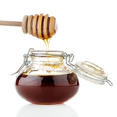 Image showing Jar of honey with wooden drizzler