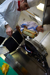 Image showing chef in hotel kitchen prepare food with fire