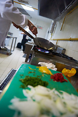 Image showing chef in hotel kitchen prepare food with fire