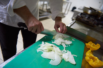 Image showing chef in hotel kitchen  slice  vegetables with knife