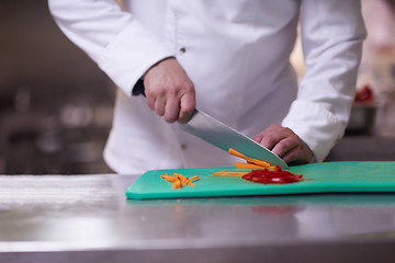 Image showing chef in hotel kitchen  slice  vegetables with knife