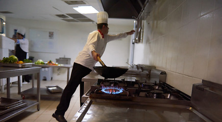 Image showing chef in hotel kitchen prepare food with fire