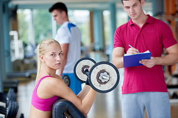 Image showing young sporty woman with trainer exercise weights lifting