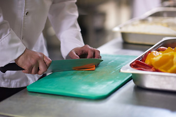 Image showing chef in hotel kitchen  slice  vegetables with knife