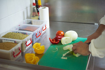 Image showing chef in hotel kitchen  slice  vegetables with knife