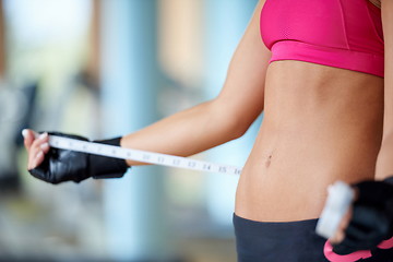 Image showing young fit woman measuring belly