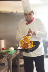 Image showing chef in hotel kitchen prepare food with fire