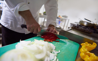 Image showing chef in hotel kitchen  slice  vegetables with knife