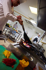 Image showing chef in hotel kitchen prepare food with fire