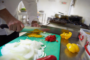 Image showing chef in hotel kitchen  slice  vegetables with knife