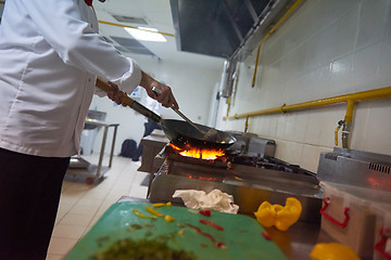 Image showing chef in hotel kitchen prepare food with fire