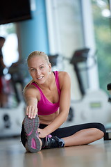 Image showing woman stretching and warming up for her training at a gym