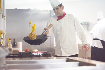 Image showing chef in hotel kitchen prepare food with fire