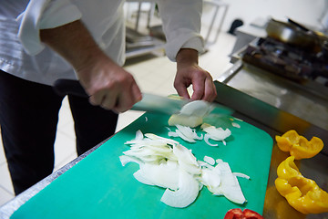 Image showing chef in hotel kitchen  slice  vegetables with knife