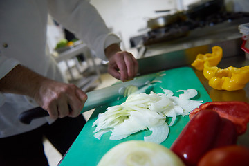 Image showing chef in hotel kitchen  slice  vegetables with knife