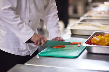 Image showing chef in hotel kitchen  slice  vegetables with knife