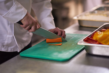 Image showing chef in hotel kitchen  slice  vegetables with knife